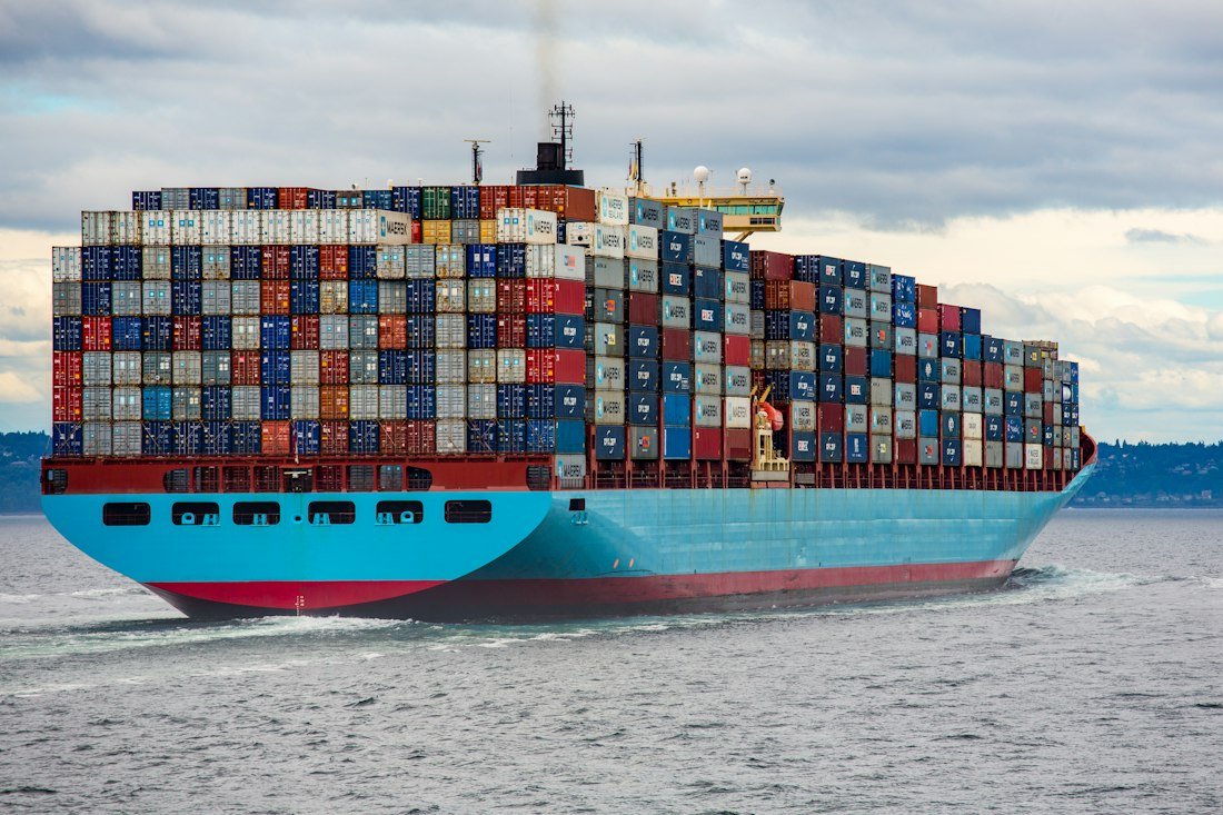 Container ship loaded with freight sailing out of port