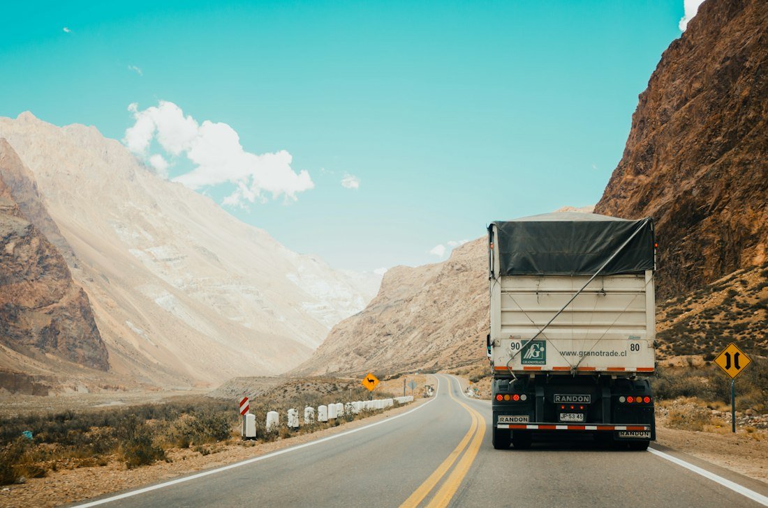 Freight truck travelling along a highway to deliver goods
