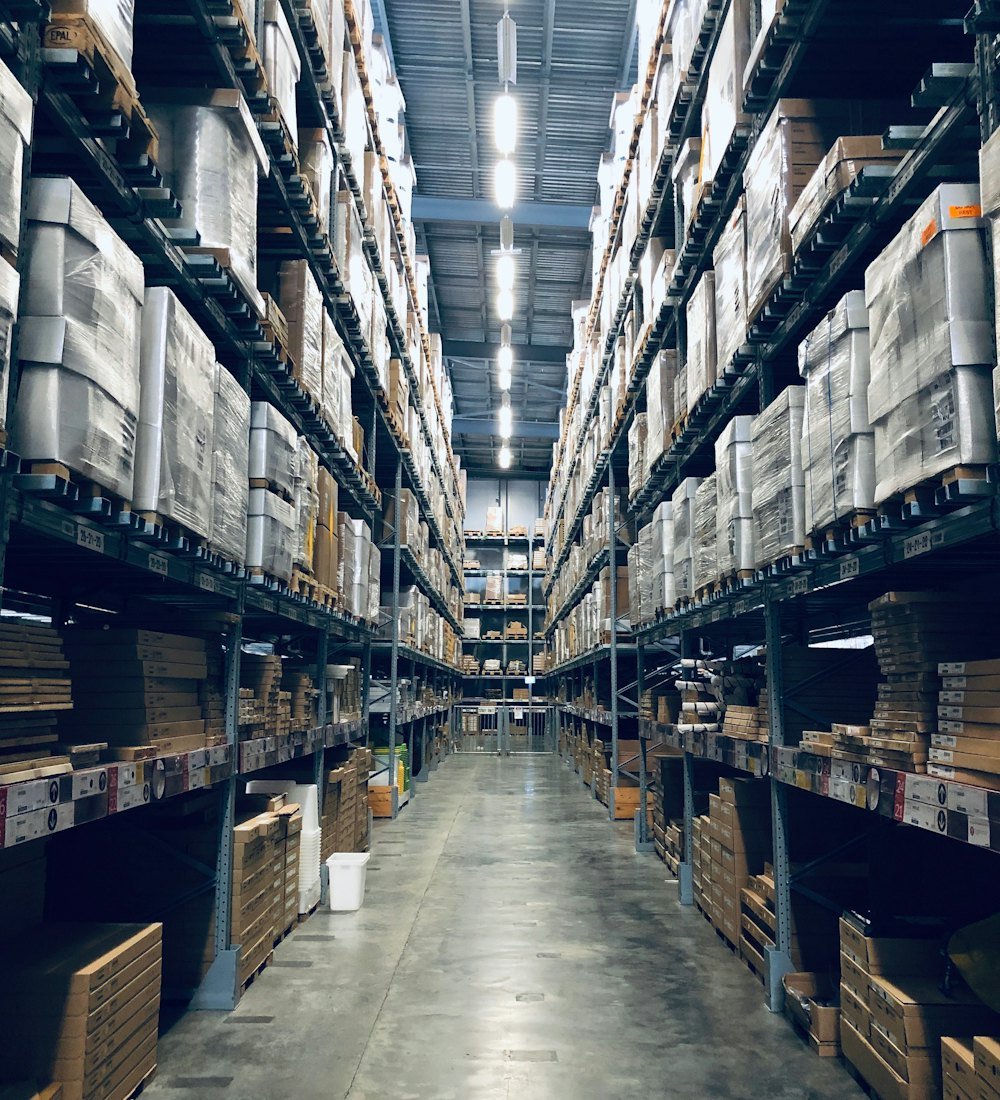 Warehouse aisle lined with palletised inventory on high racking