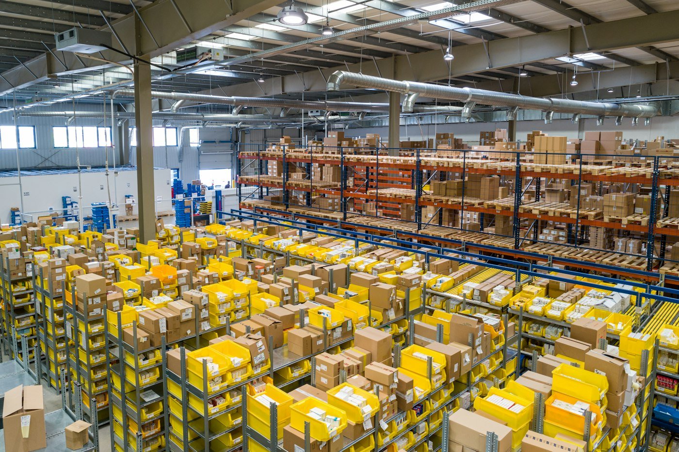 Distribution warehouse with stocked racking and order-picking bins