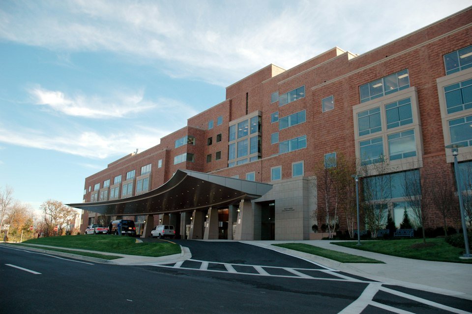Modern hospital building with a covered entrance and landscaped grounds